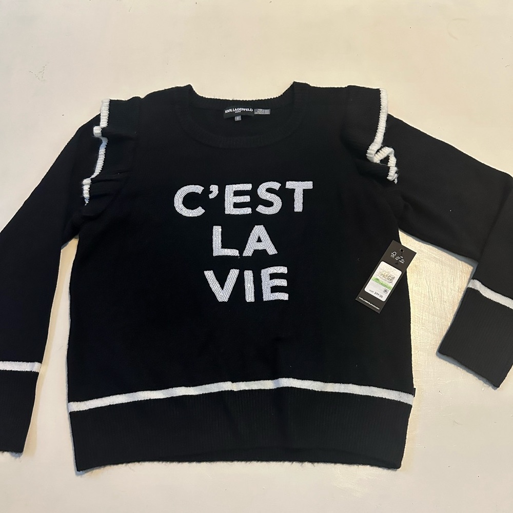 Women’s black sweater with ruffle sleeve. New with tags, glitter letter front.